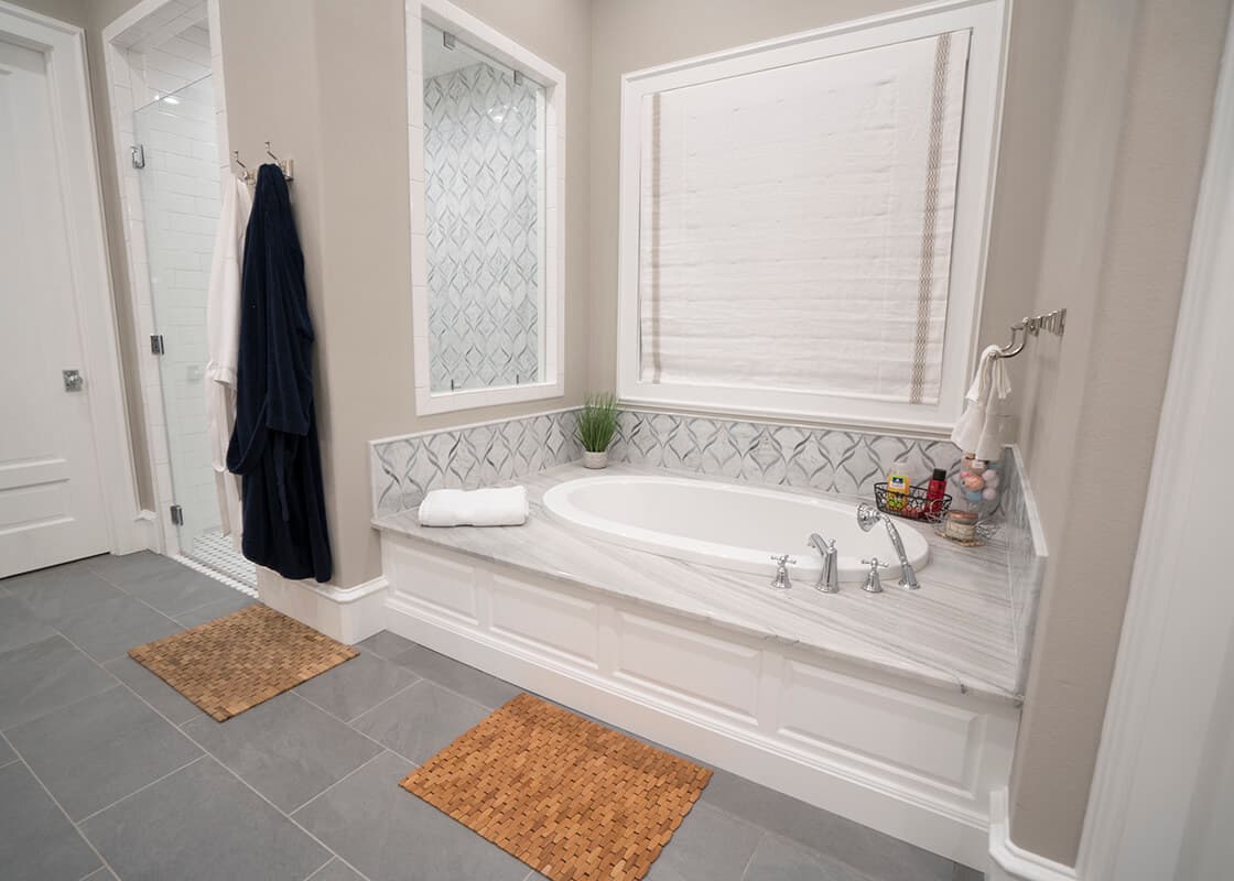 Finished tub surround with coordinated stone and tile details
